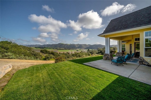 view of yard featuring a mountain view and a patio area