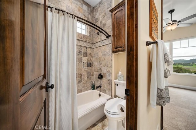 bathroom featuring ceiling fan, shower / tub combo with curtain, and toilet