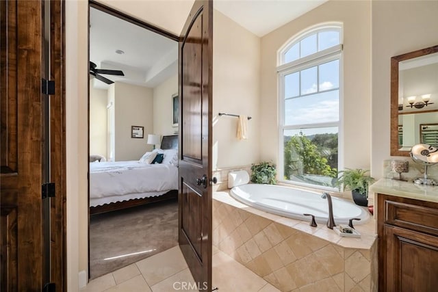 bathroom with vanity, tile patterned floors, tiled bath, and ceiling fan