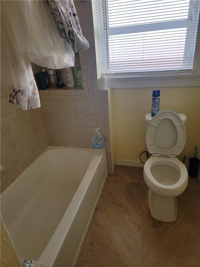 bathroom featuring a bath and toilet