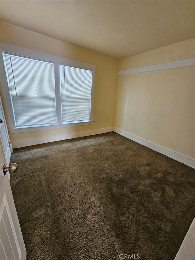 carpeted empty room featuring baseboards
