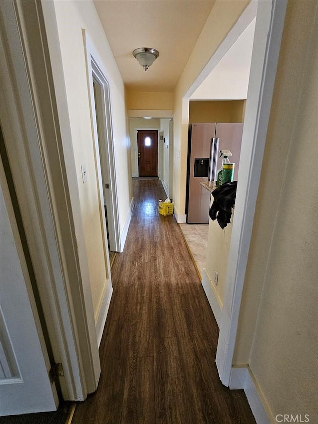 hall with baseboards and wood finished floors