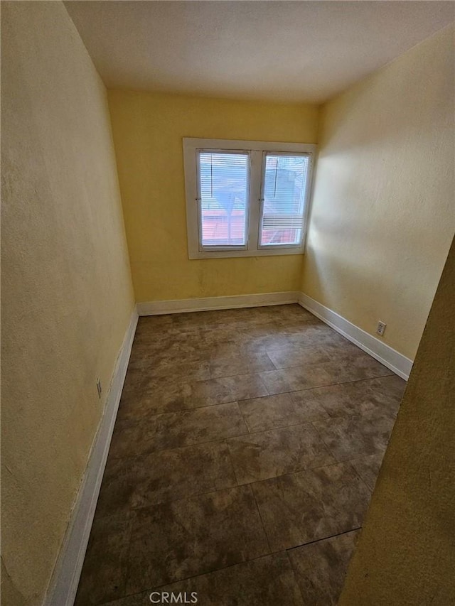 unfurnished room featuring baseboards