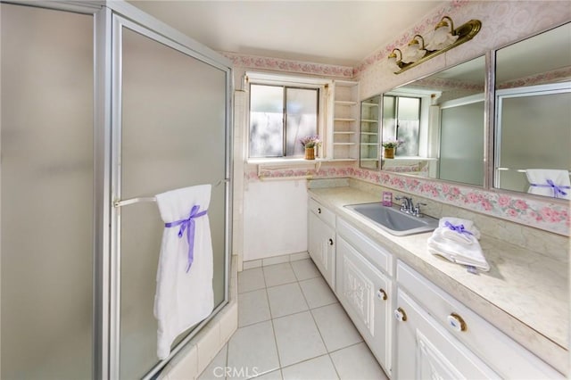 bathroom featuring tile patterned flooring, vanity, and a shower with door