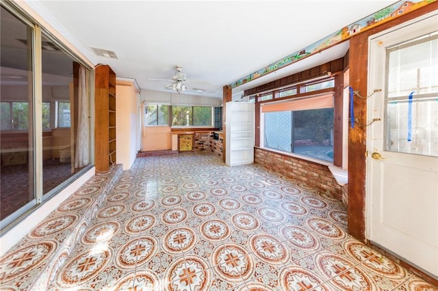 unfurnished sunroom featuring ceiling fan