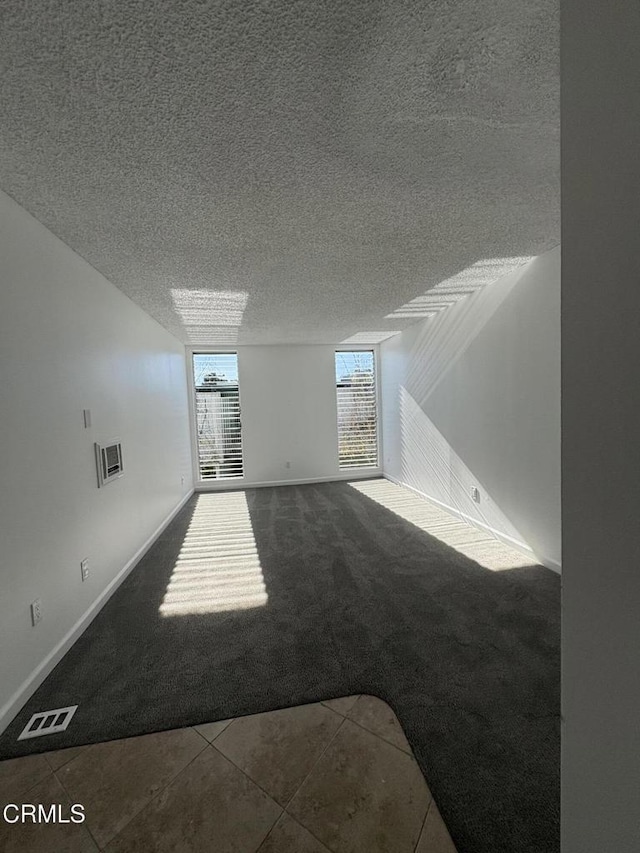 spare room with a textured ceiling and carpet flooring