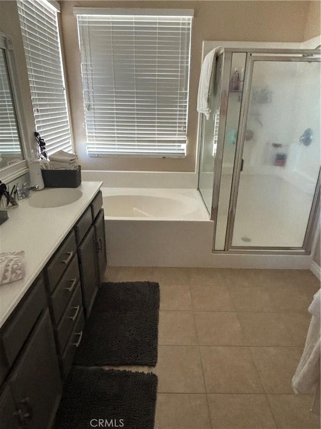 bathroom with vanity, tile patterned floors, and plus walk in shower