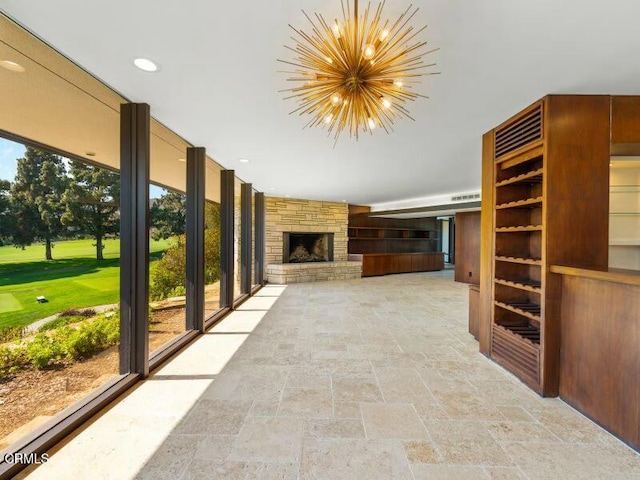 unfurnished living room featuring a chandelier and a fireplace