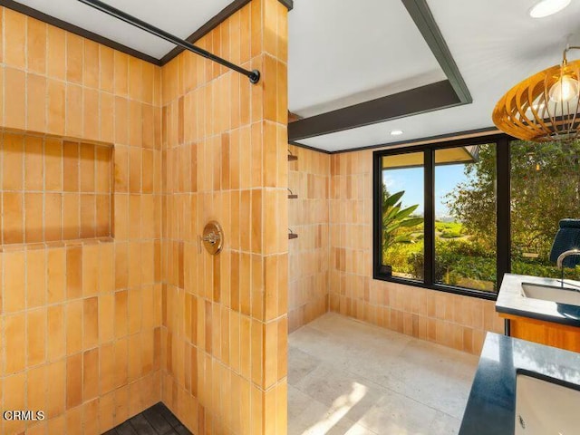 bathroom with sink, tile walls, and tiled shower