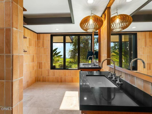 bathroom featuring vanity, plenty of natural light, and tile walls