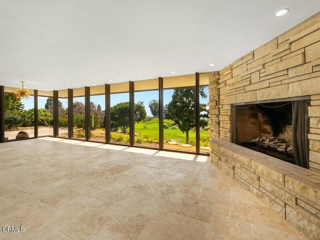 unfurnished living room featuring a wall of windows and a fireplace