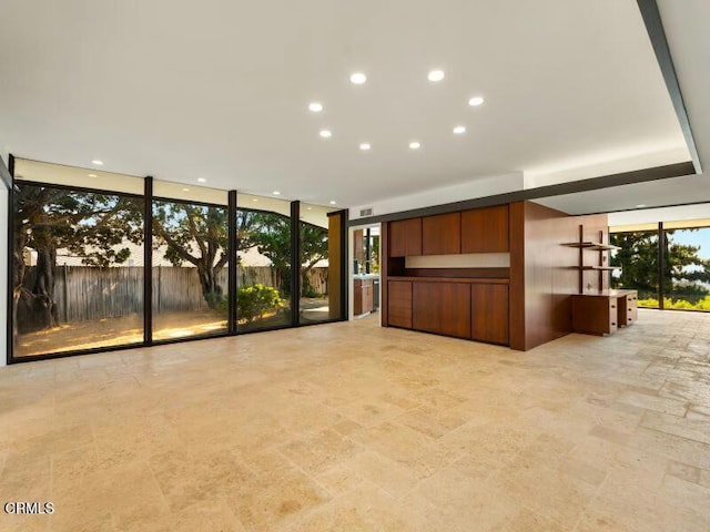 interior space with a wall of windows, recessed lighting, and stone finish flooring