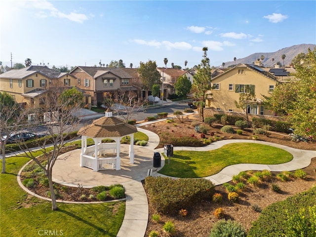 view of property's community with a yard, a gazebo, and a mountain view