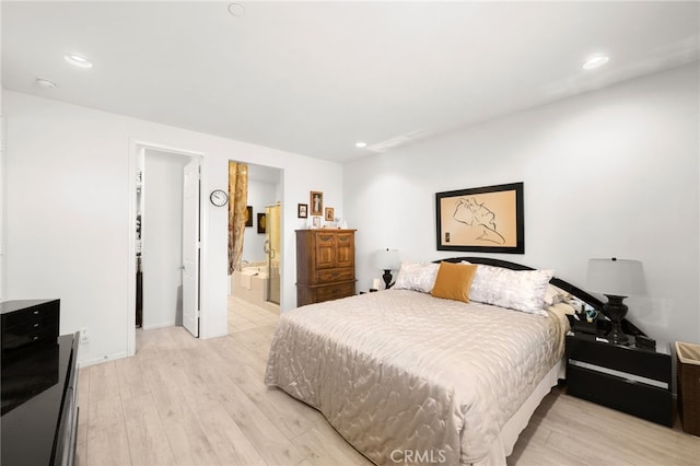 bedroom with ensuite bathroom and light hardwood / wood-style floors