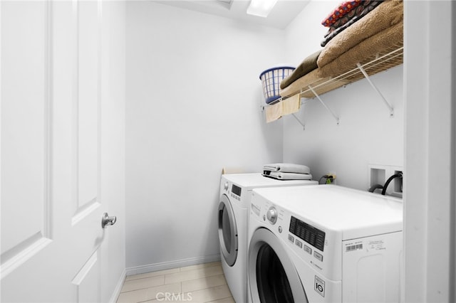 clothes washing area featuring washer and dryer and light tile patterned flooring