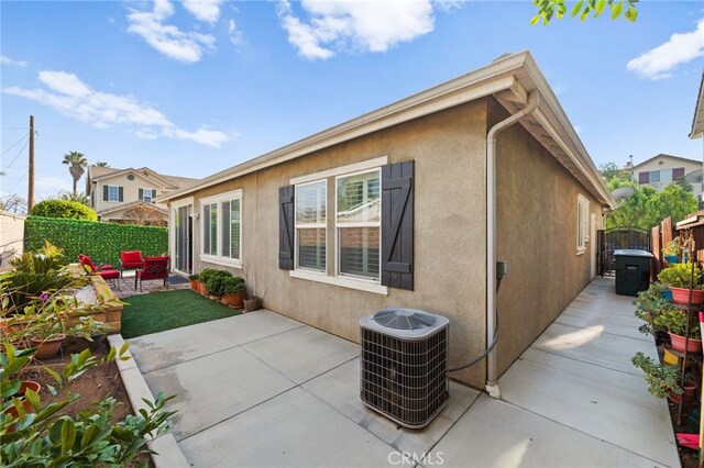 view of property exterior with cooling unit and a patio