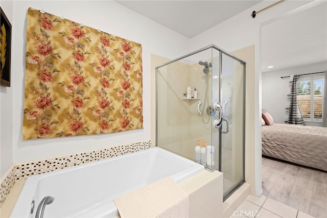 bathroom with tile patterned flooring and shower with separate bathtub