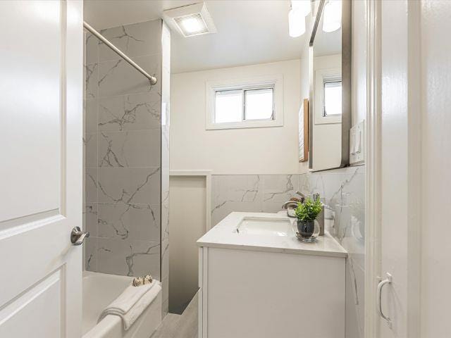 bathroom featuring vanity and tiled shower / bath combo