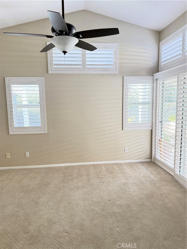 unfurnished room with ceiling fan, light colored carpet, plenty of natural light, and vaulted ceiling