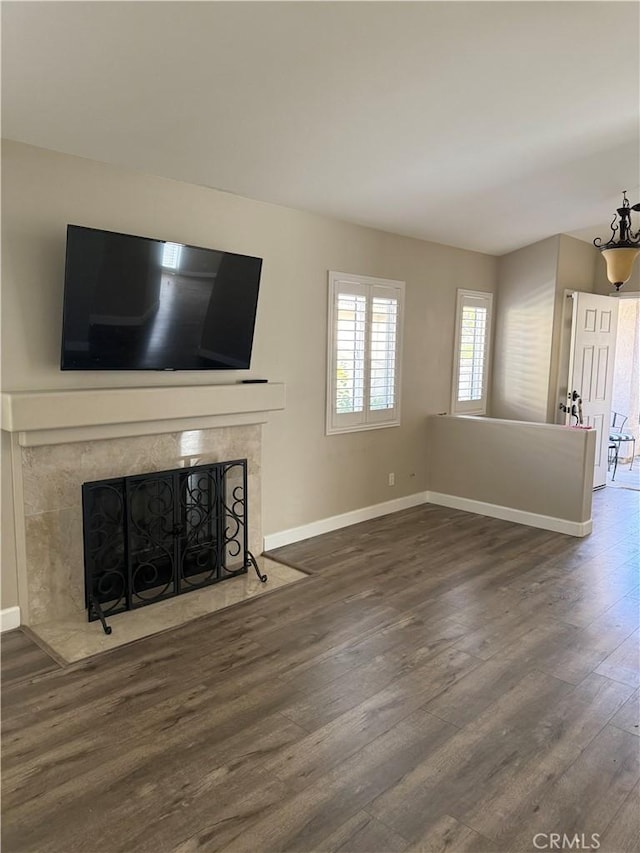 unfurnished living room with dark wood-type flooring and a fireplace