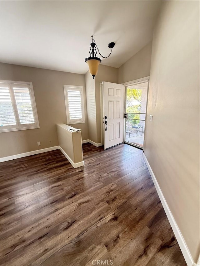 foyer with dark hardwood / wood-style flooring, vaulted ceiling, and a wealth of natural light