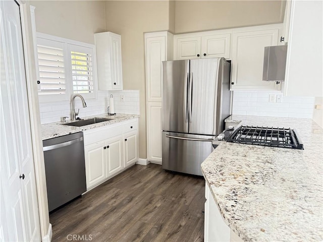 kitchen featuring white cabinetry, sink, light stone counters, and appliances with stainless steel finishes