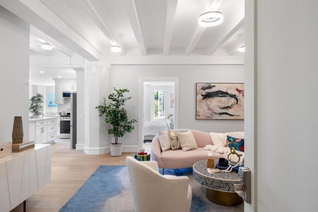 living room with light hardwood / wood-style floors and beamed ceiling