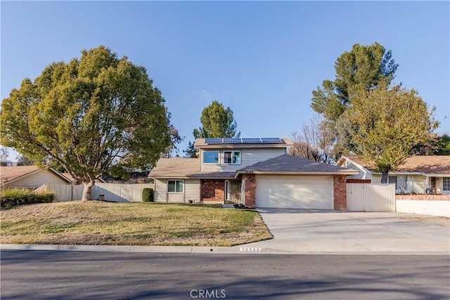 view of front of property with a garage, a front yard, and solar panels