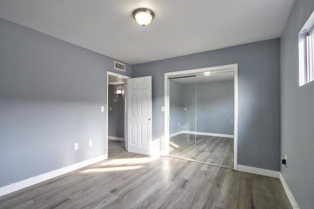 unfurnished bedroom featuring hardwood / wood-style floors and a closet