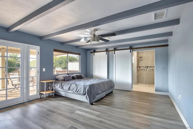 bedroom with access to exterior, ensuite bath, hardwood / wood-style flooring, beamed ceiling, and a barn door