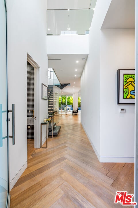 corridor with a towering ceiling and light parquet floors