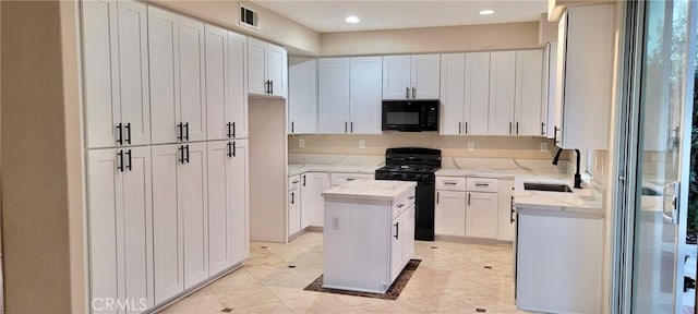 kitchen with a center island, sink, white cabinets, and black appliances