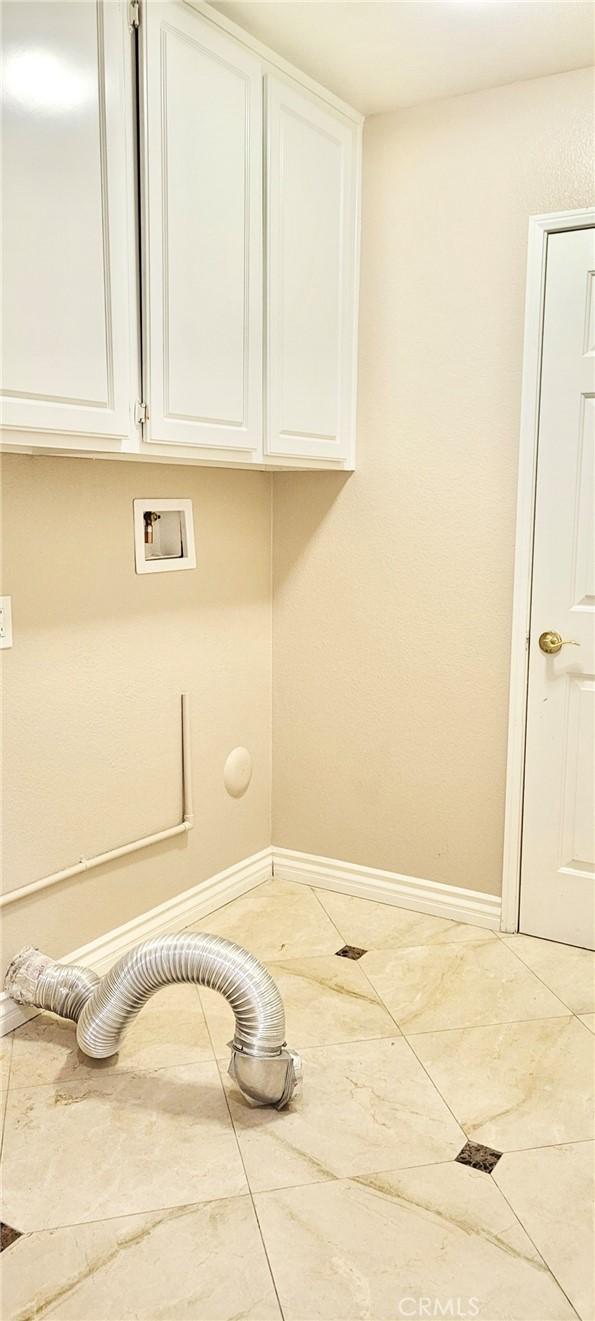 laundry area featuring cabinets, hookup for a washing machine, and tile patterned flooring