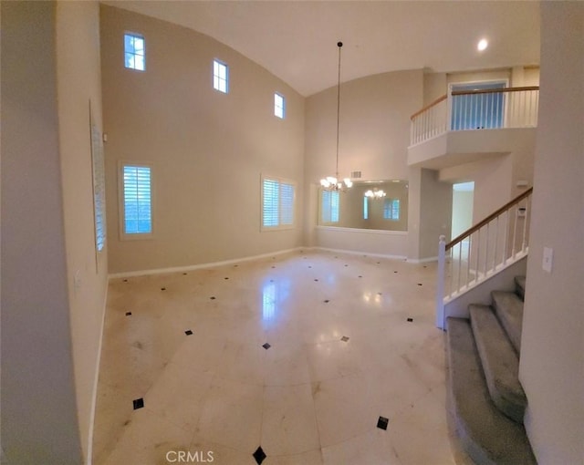 unfurnished living room featuring a chandelier and a high ceiling