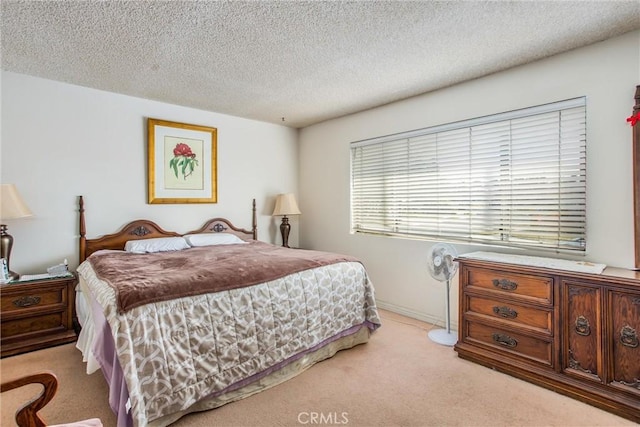 bedroom with light carpet and a textured ceiling