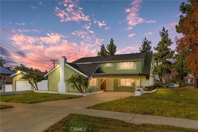 view of front of home with a garage and a yard