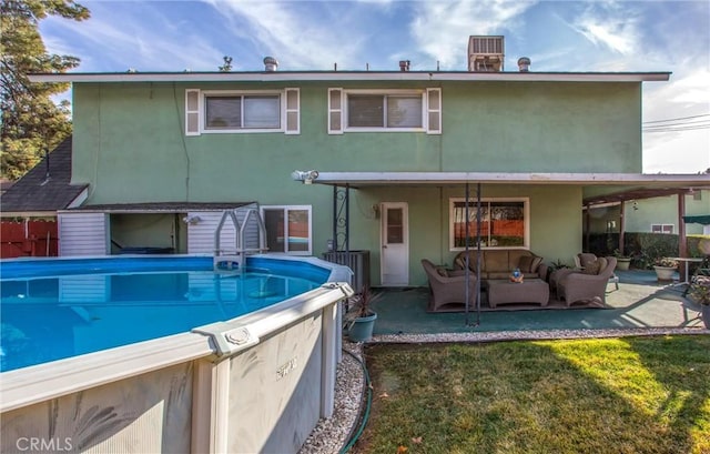 back of house featuring a patio, an outdoor hangout area, and a lawn