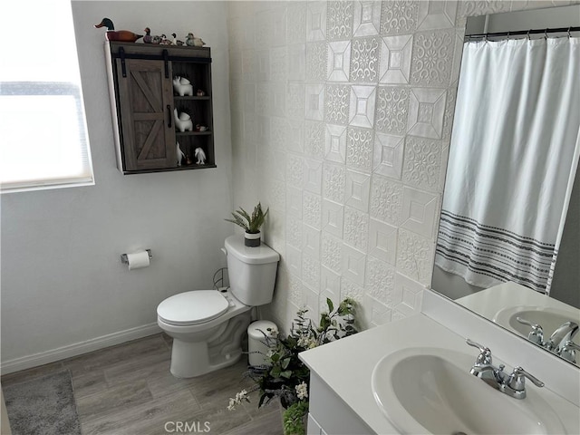 bathroom featuring hardwood / wood-style flooring, vanity, toilet, and curtained shower