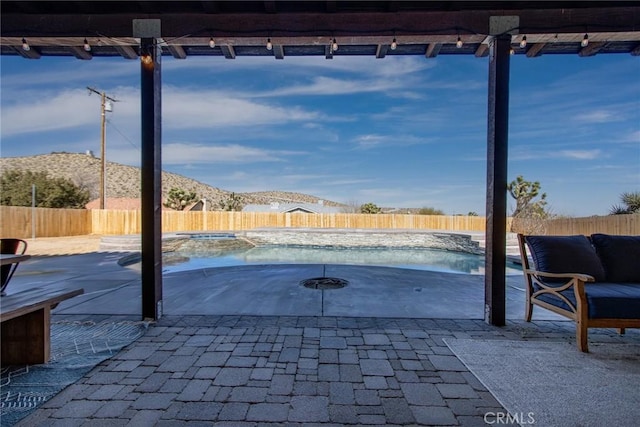 view of patio featuring a mountain view and a fenced in pool