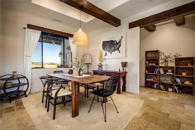 dining area featuring beam ceiling