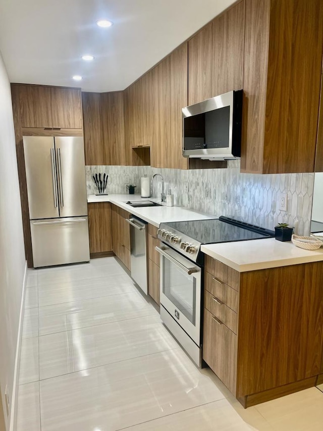 kitchen with appliances with stainless steel finishes, sink, and decorative backsplash