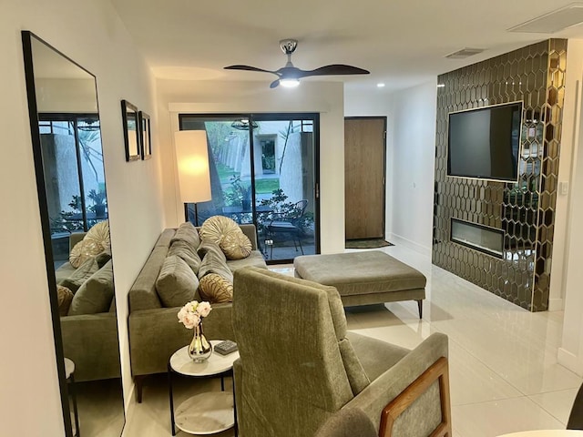 tiled living room featuring ceiling fan and a fireplace