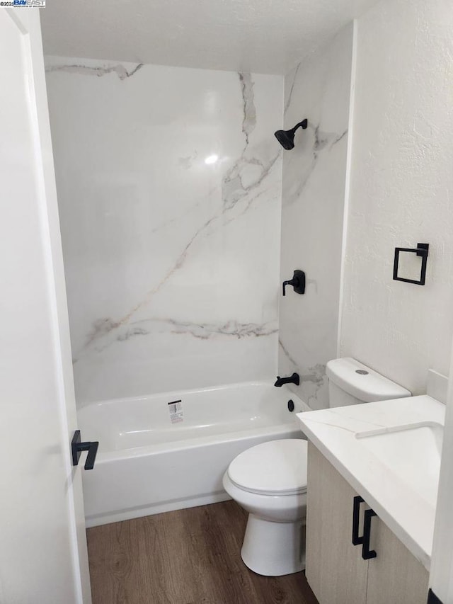 full bathroom featuring tiled shower / bath, vanity, toilet, and hardwood / wood-style floors