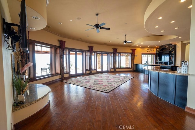 unfurnished living room with dark hardwood / wood-style floors and ceiling fan