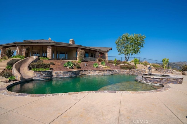 view of pool with a water slide and a patio area