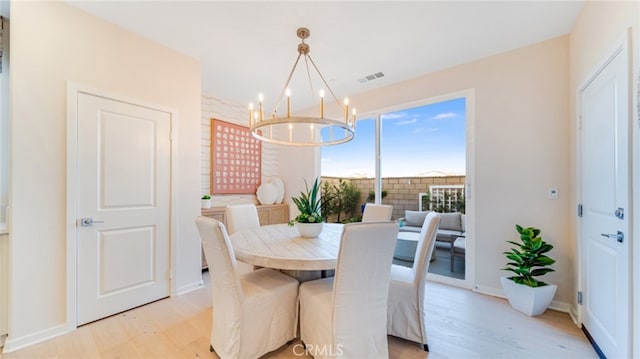 dining area with an inviting chandelier and light hardwood / wood-style floors