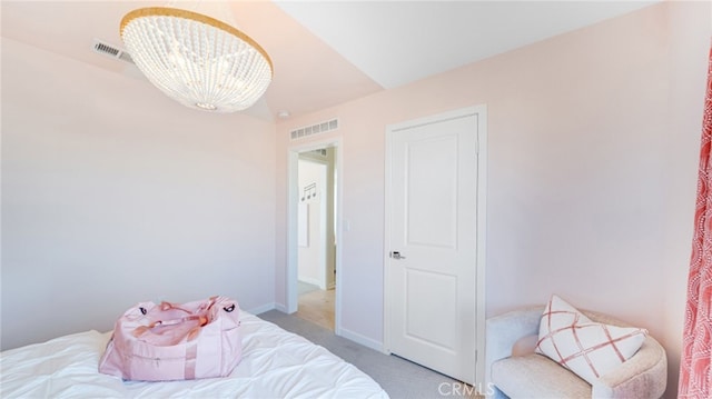 carpeted bedroom with an inviting chandelier