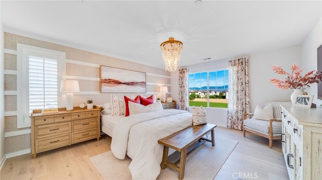 bedroom featuring an inviting chandelier and light wood-type flooring