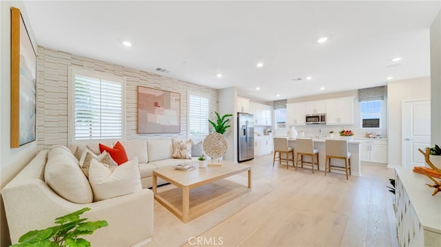 living room featuring sink and light wood-type flooring