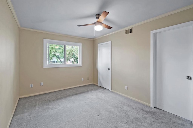 unfurnished bedroom featuring ceiling fan, light colored carpet, and ornamental molding